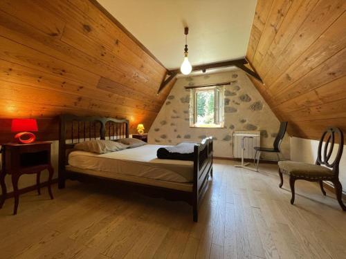 a bedroom with a bed and a wooden ceiling at B&B - Chambres d'Hôtes Acoucoula in Orthez
