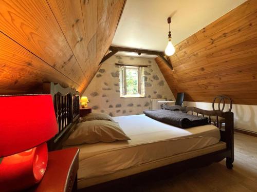 a bedroom with a large bed in a room with wooden walls at B&B - Chambres d'Hôtes Acoucoula in Orthez