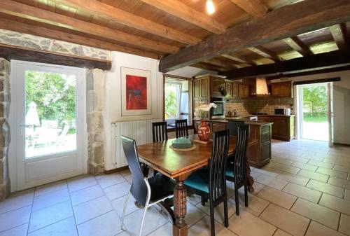 a kitchen and dining room with a wooden table and chairs at B&B - Chambres d'Hôtes Acoucoula in Orthez