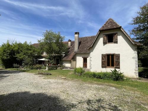 an old white house with a gravel driveway at B&B - Chambres d'Hôtes Acoucoula in Orthez
