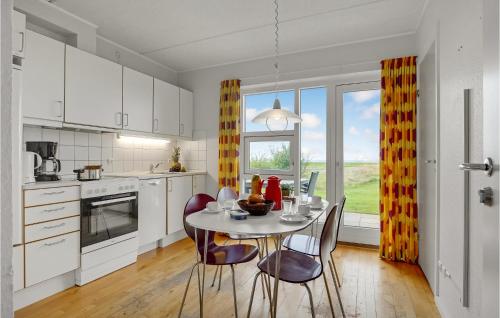 a kitchen with a table and chairs and a kitchen with a window at 2 Bedroom Stunning Home In Højer in Højer