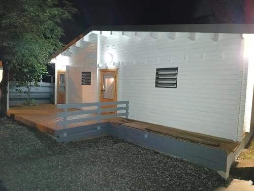 a small white building with a wooden deck at Kaz Samèm in Les Avirons