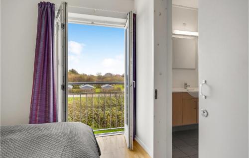 a bedroom with a door open to a balcony at 2 Bedroom Stunning Home In Højer in Højer