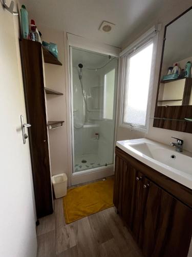 une salle de bain avec un lavabo et une douche dans l'établissement Superbe Mobilehome 3 ch, climatisé tout confort, à Onesse-et-Laharie