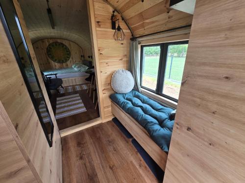 an interior view of a tiny house with a blue couch at Oaza Święty Spokój - domek z balią i jacuzzi in Rząśnik