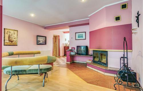 a living room with pink walls and a fireplace at 8 Bedroom Beautiful Home In Miastko in Starzno