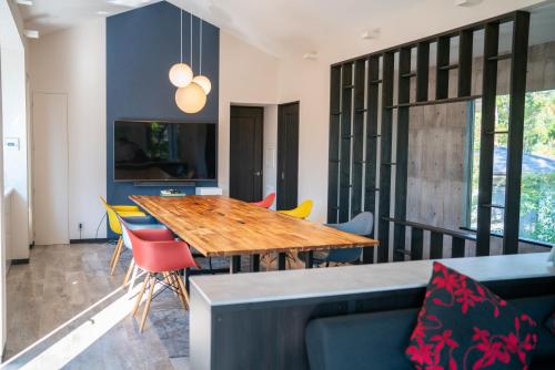 a dining room with a wooden table and chairs at Villa By Nature in Yawatano