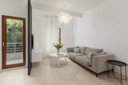 a living room with a couch and a table at Mosaic Penthouse Condo with Sea View in Risan