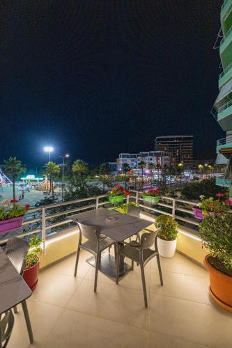 a table and chairs on a balcony at night at Veranda Boutique Hotel in Vlorë