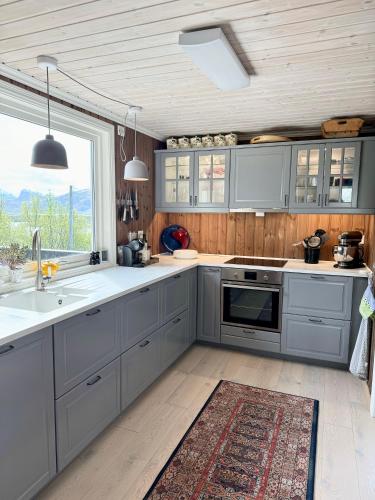 a kitchen with gray cabinets and a large window at Amazing seaview - Lodge in Bodø