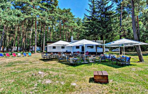 a group of tables and chairs under umbrellas at Beautiful Home In Sulnowo With Sauna in Sulnówko