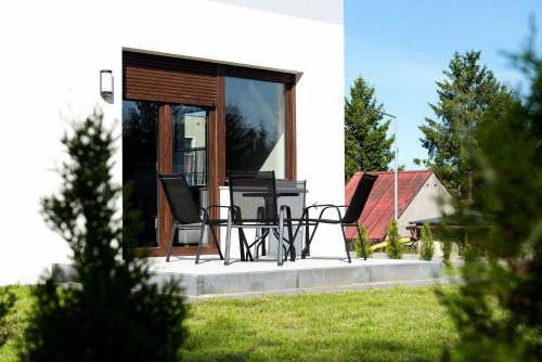 a pair of chairs sitting on the front porch of a house at Apartamenty Parkowe in Łęknica