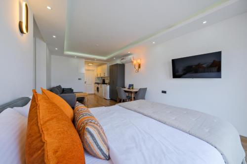 a bedroom with a white bed and a living room at Körfez Residence in Fethiye