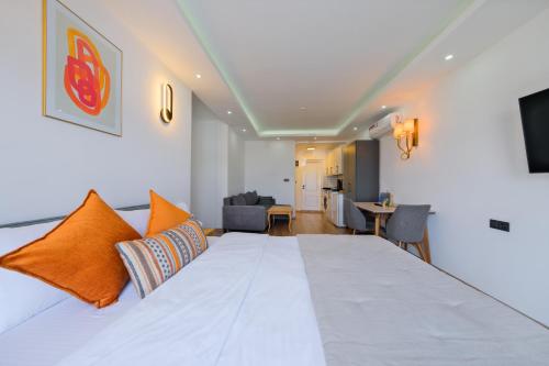 a bedroom with a large white bed with orange pillows at Körfez Residence in Fethiye