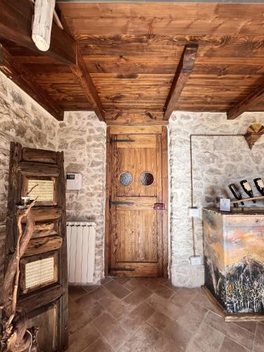 a room with a wooden door and a stone wall at Il Palazz8 - Dimore di Charme in San Polo dei Cavalieri