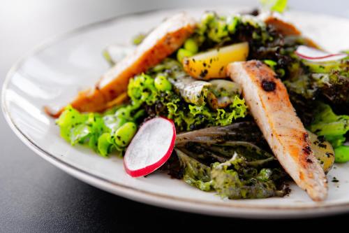 a plate of food with vegetables on a table at Tut Winten a Tranquil Living Villa Ubud in Ubud