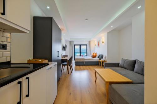 a kitchen and living room with a couch and a table at Körfez Residence in Fethiye
