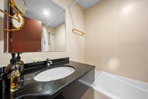 a bathroom with a sink and a mirror and a tub at Studio in Dubai