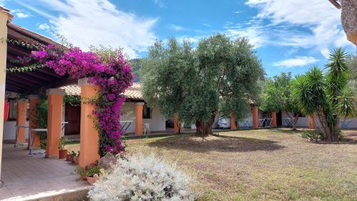 a building with purple flowers on the side of it at Hotel Cardedu in Cardedu