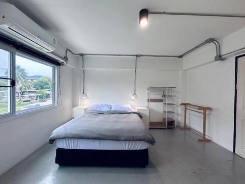 トンサラにあるPrachan Hostelの窓付きの部屋にベッド付きのベッドルーム1室があります。