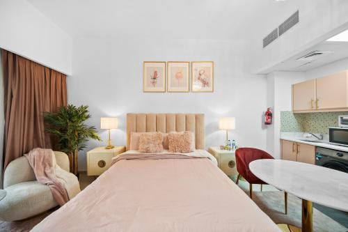 a bedroom with a large bed and a table and chairs at Studio in Dubai