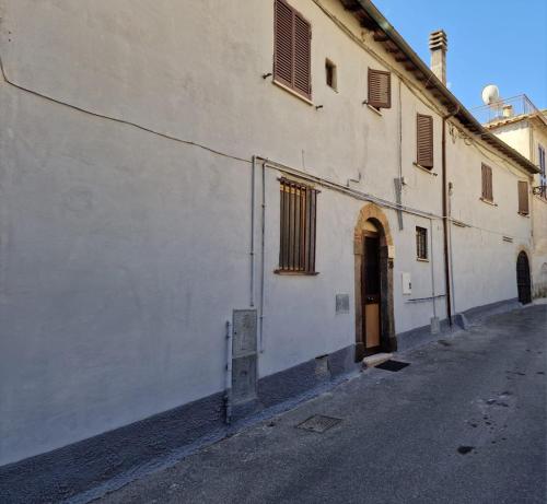 a white building with a door on the side of a street at La Casa dei Ricordi in Campagnano di Roma