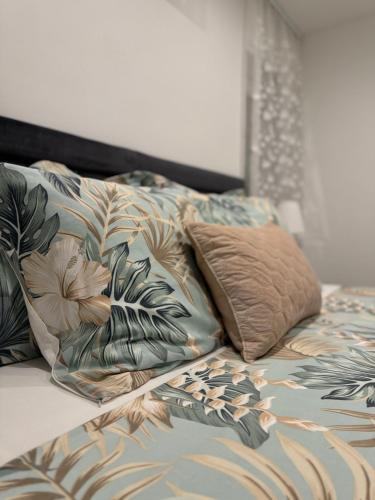 a bed with a comforter and two pillows on it at HelaMoni, New 5 Star 2 Person apartments with pool in Malinska