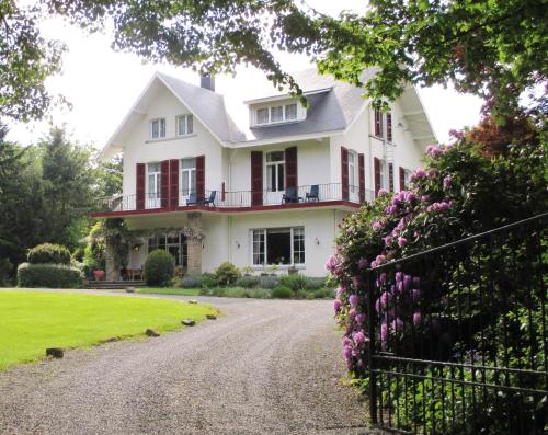 a white house with a fence and flowers at Hotel La Heid des Pairs in Spa