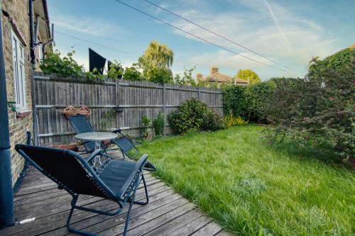 a patio with two chairs and a table on a deck at Immaculate Condition 3 Bed En-Suite Refurbished House in Goodmayes