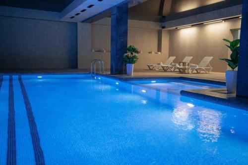 a large swimming pool with blue water in a building at Kohinur Plaza in Samarkand