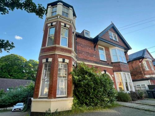 a large brick building with a tall tower at Delightful One Bed Victorian Flat in Hastings