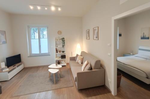 a living room with a couch and a bed at Santa Chiara NUOVO Appartamento in centro di Bra in Bra