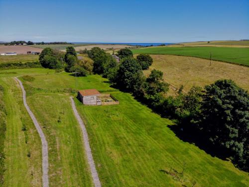 an aerial view of a small house in a field at Anniston Mill Cabin 2 in Arbroath