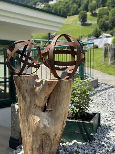 a sculpture of two glasses on top of a tree stump at Hotel Senningerbräu in Bramberg am Wildkogel