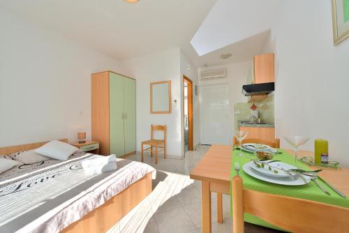 ein Schlafzimmer mit einem Bett und einem Tisch mit Tellern darauf in der Unterkunft Sara Apartments in Petrcane