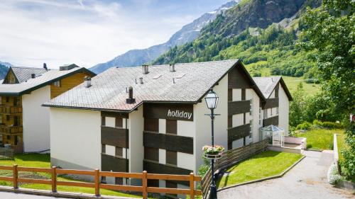 a hotel with mountains in the background at Lady Hamilton in Leukerbad