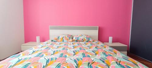 une chambre avec un lit avec un mur rose dans l'établissement Belle Maison d Armateur Sablais - Les Sables d Olonne, à Les Sables-dʼOlonne