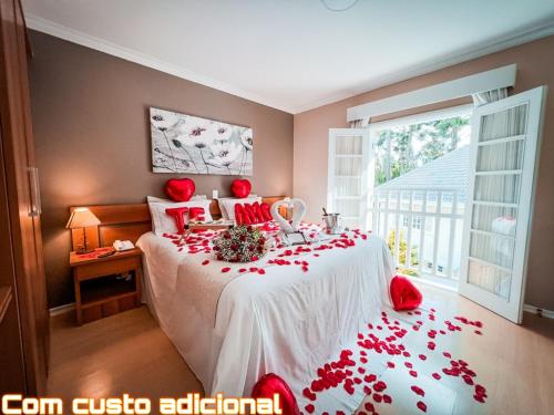 a bedroom with a bed with red roses on it at Pousada Nacional Inn Campos do Jordão in Campos do Jordão
