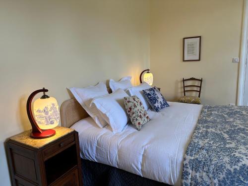 a bedroom with a bed with white sheets and pillows at L'enthousiasme in Prades