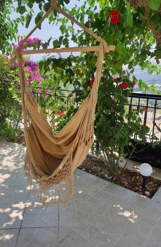 a hammock hanging from a tree with flowers at TheYellow House II Fully Equipped 2BR apartment in Pilaroú