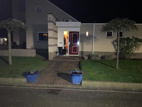 a house with two blue pots in front of the door at La Nuova Casa del Campo (vh De Kamp) in Dinxperlo
