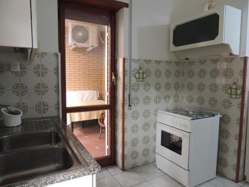 a kitchen with a sink and a stove at La casa di Maro in Lido di Ostia