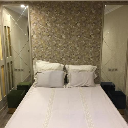 Elle comprend un grand lit avec des draps et des oreillers blancs. dans l'établissement Calme, lumineux, luxueux, refait á neuf, à Sartrouville