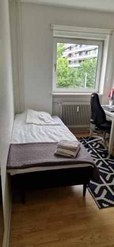 a bedroom with a bed and a desk and a window at HomeStay with Bo in Copenhagen