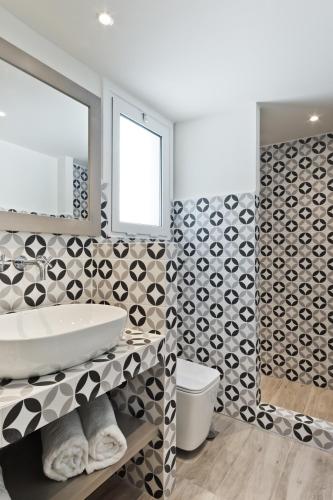 a bathroom with a sink and a toilet at Posidonia Luxury Suites in Karpathos