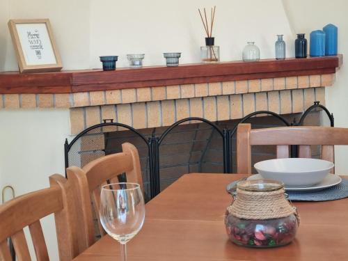a wooden table with a wine glass on top of it at TheYellow House II Fully Equipped 2BR apartment in Pilaroú