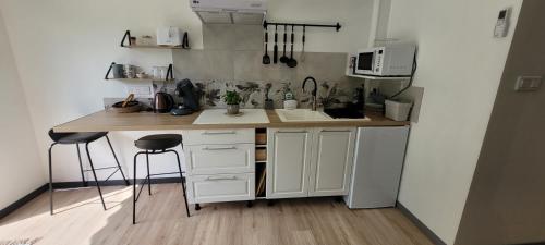 a kitchen with a sink and a counter with stools at les Versannes in Lamonzie-Montastruc
