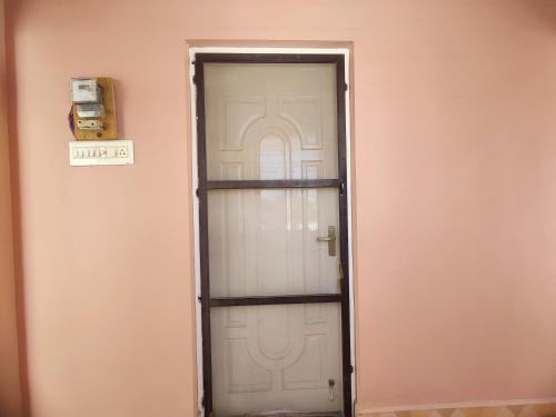 a white door in a pink wall at Maison Douce in Chennai