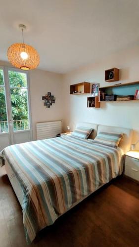 une chambre avec un grand lit avec une couverture colorée dans l'établissement Villa Libellule à Vence, à Vence