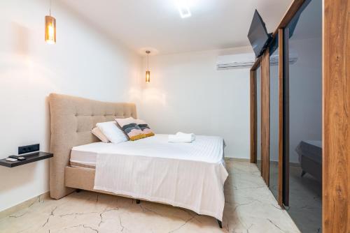 a bedroom with a bed and a tv on a wall at Villa Zita Lovran in Opric